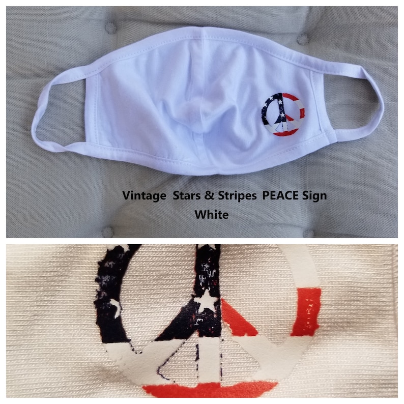 Puede incluir: M&aacute;scara facial blanca con un dise&ntilde;o de signo de paz de bandera estadounidense vintage. El signo de paz es rojo, blanco y azul con estrellas y rayas.