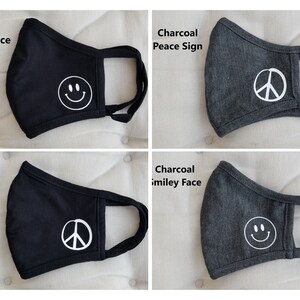 Puede incluir: Cuatro mascarillas reutilizables para la cara, dos negras y dos grises antracita. Dos mascarillas presentan un s&iacute;mbolo de paz blanco y dos mascarillas presentan una cara sonriente blanca. Las mascarillas est&aacute;n hechas de un tejido suave y c&oacute;modo.
