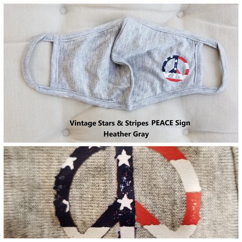 Puede incluir: M&aacute;scara facial gris con un dise&ntilde;o de signo de paz con estrellas y rayas rojas, blancas y azules. El texto "Vintage Stars & Stripes PEACE Sign Heather Gray" est&aacute; debajo de la m&aacute;scara.