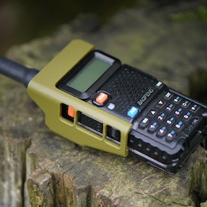 May include: A green and black two-way radio with a keypad and a screen. The radio has a Baofeng logo and a black antenna.