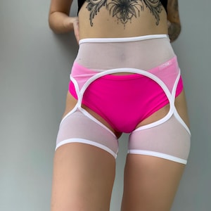 May include: A two-piece lingerie set featuring a bright pink bottom and a white and sheer top with white trim. The set is designed with a high waist and cut-out details, offering a modern and bold look.