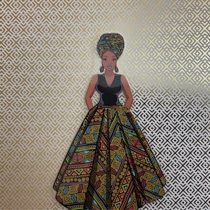 Op de afbeelding: Een vrouw in een zwarte jurk met een kleurrijke, gepatroneerde rok en een hoofddoek. De achtergrond is een goud-wit geometrisch patroon.
