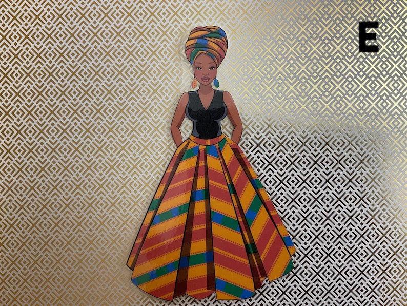 Op de afbeelding: Een vrouw die een zwarte, mouwloze jurk draagt met een kleurrijke, gepatroneerde rok en een hoofddoek. De achtergrond is een goud-wit geometrisch patroon.