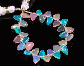 May include: A strand of iridescent opal beads in a teardrop shape. The beads are a mix of pink, blue, and white.