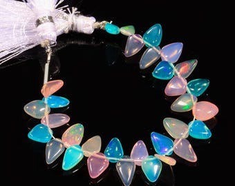 May include: A strand of iridescent opal beads in shades of pink, blue, and white. The beads are faceted and have a teardrop shape. The strand is strung on a clear thread and has a white tassel at one end.