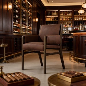May include: A brown leather armchair with a dark wooden frame, featuring a square backrest, padded armrests, and a seat cushion. The chair is positioned in a room with dark wood paneling, wine racks, and a bar counter in the background.