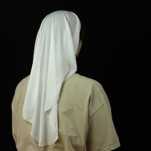 May include: A solid white chapel veil made of a lightweight, flowing fabric draped over the head, extending down the back. The veil features a smooth, finished edge and is worn over a plain tan t-shirt. Text in the corner reads Petunia Pattern.