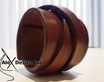Puede incluir: Un brazalete de cuero marrón con un diseño sencillo. El brazalete está hecho de varias capas de cuero cosidas juntas.