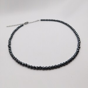 May include: A black hematite beaded necklace with a silver clasp.