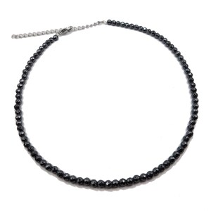 May include: A black beaded necklace with a silver clasp. The necklace is made of small, round beads.