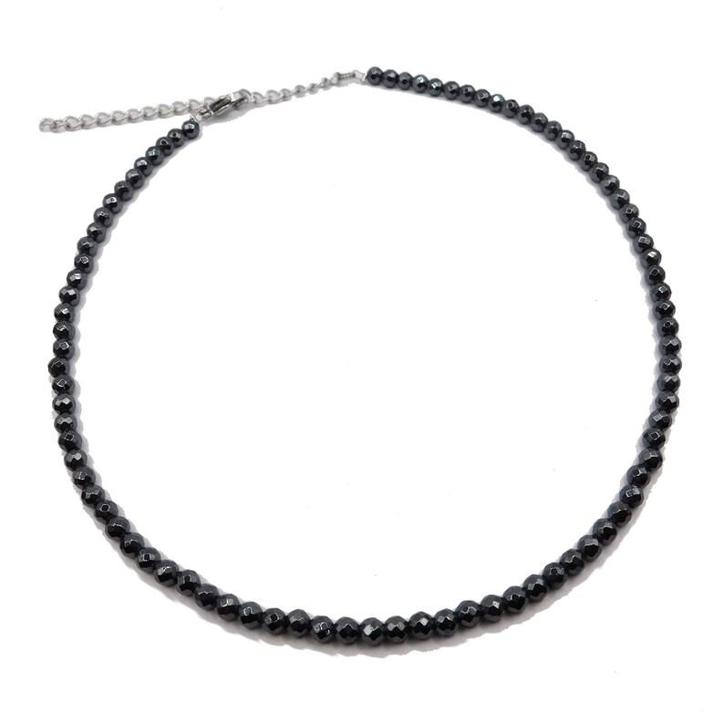 May include: A black beaded necklace with a silver clasp. The necklace is made of small, round beads.