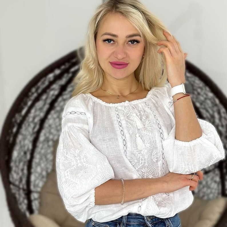 White on white vyshyvanka blouse with folk floral embroidery. Linen peasant blouse for women features puff sleeves that are decorated with ukrainian embroidery and lace. Linen top has 3/4 sleeves.