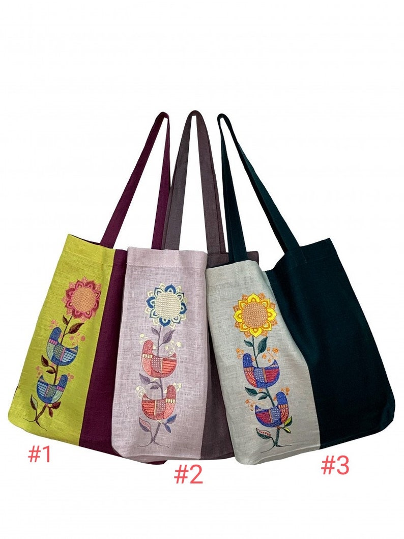 Puede incluir: Cuatro bolsas de mano con dise&ntilde;os florales y de p&aacute;jaros bordados. Las bolsas tienen paneles de diferentes colores, incluyendo verde, morado y gris. Cada bolsa presenta una correa larga y un patr&oacute;n bordado &uacute;nico. Las bolsas est&aacute;n numeradas.