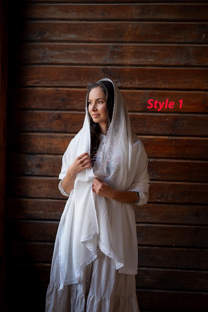 Puede incluir: Una mujer con un vestido y un velo de lino blanco, adornados con encaje. El atuendo tiene un dise&ntilde;o fluido y modesto. El texto "Style 1" es visible en la imagen.