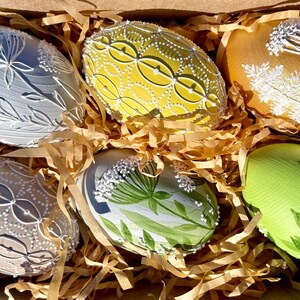Set of 6 hand-painted Easter eggs in soft pastel green, grey, yellow and beige tones with white botanical line art, gold details and pearl dots