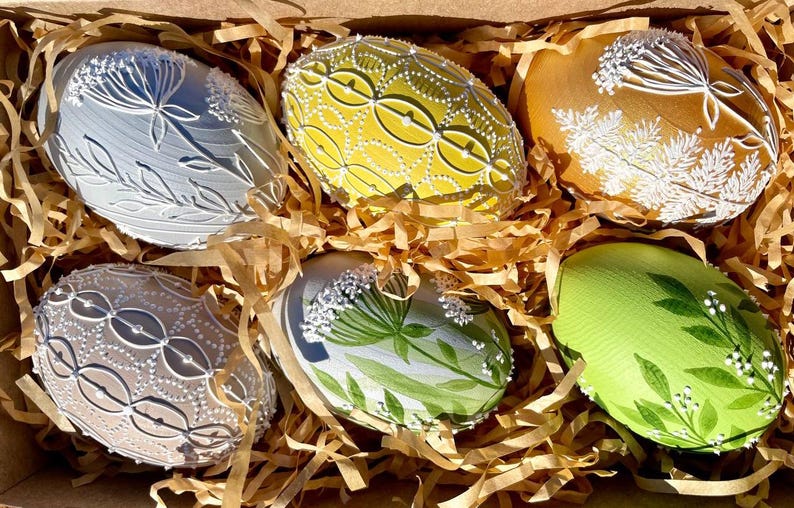 Set of 6 hand-painted Easter eggs in soft pastel green, grey, yellow and beige tones with white botanical line art, gold details and pearl dots