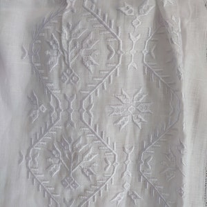 Peut inclure: Tissu de lin blanc avec un motif brod&eacute; blanc. Le motif pr&eacute;sente des formes g&eacute;om&eacute;triques et des motifs.