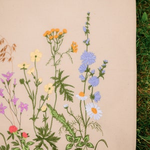 Beige canvas tote bag with botanical embroidery.