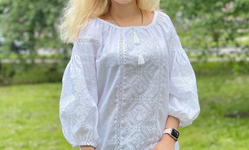 White on white vyshyvanka blouse with folk floral embroidery. Linen peasant blouse for women features puff sleeves that are decorated with ukrainian embroidery and lace. Linen top has 3/4 sleeves.