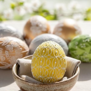 Set of 6 hand-painted Easter eggs in soft pastel green, grey, yellow and beige tones with white botanical line art, gold details and pearl dots
