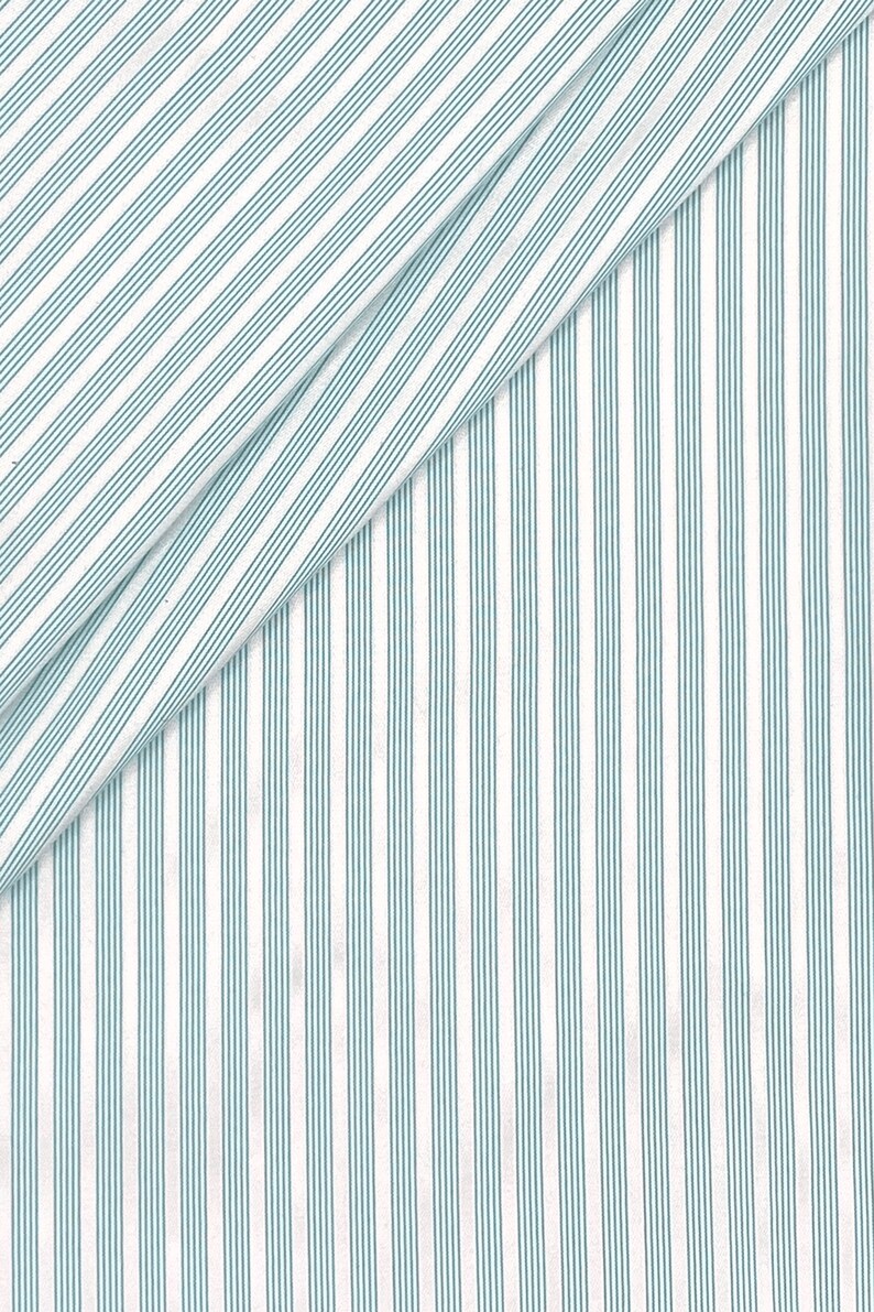 Puede incluir: Tela blanca con finas rayas azul verdosas. La tela est&aacute; doblada por la mitad, creando una l&iacute;nea diagonal.