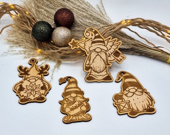 May include: Four wooden Christmas ornaments featuring gnomes with different designs. One gnome is holding a star, another is holding a lantern, and another is wearing reindeer antlers. The fourth gnome is holding a musical instrument.