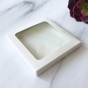 May include: White cardboard box with a clear window, perfect for packaging small items.