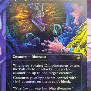 May include: A collectible trading card titled "Spitting Dilophosaurus" featuring a detailed illustration of a dinosaur spitting at a person. The card has a holographic finish and includes text describing the creature's abilities and flavor text from the Jurassic Park franchise.