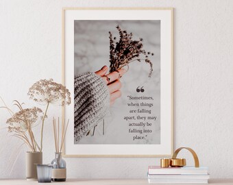 May include: A framed print with a quote about falling apart and falling into place. The quote is printed in black text on a white background. The image features a hand holding a bouquet of dried lavender.