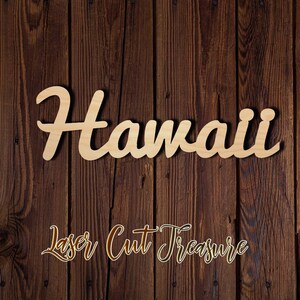 May include: A wooden sign with the word "Hawaii" written in a cursive font. The sign is laser cut and has a natural wood finish. The sign is on a brown wooden background.