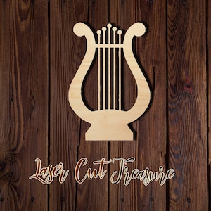 May include: A wooden cutout of a lyre, a stringed musical instrument, against a dark brown wood background. The text "Laser Cut Treasure" is visible below the lyre.