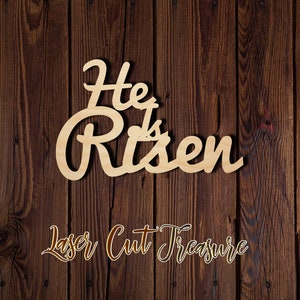 May include: Wooden sign with the words "He is Risen" in a cursive font. The sign is on a brown wood background. The words "Laser Cut Treasure" are written below the sign.