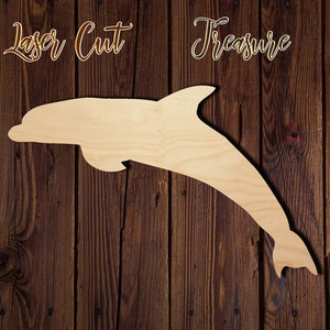 May include: Laser cut wooden dolphin shape, a blank craft supply for painting, staining, or decorating.  The dolphin is facing right and is jumping out of the water.