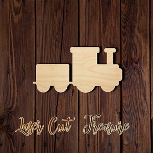 May include: Wooden cutout of a train engine and a train car. The cutout is on a brown wood background. The text "Laser Cut Treasure" is below the cutout.