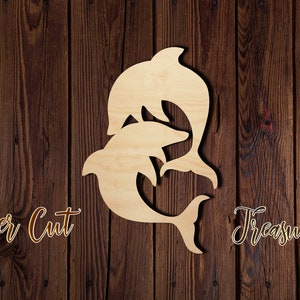 May include: Laser cut wooden cutout of two dolphins, one on top of the other, against a brown wood background. The text "Laser Cut Treasure" is visible below the dolphins.
