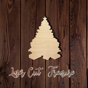May include: A wooden cutout of a Christmas tree with a star on top. The tree is on a brown wood background. The text "Laser Cut Treasure" is below the tree.