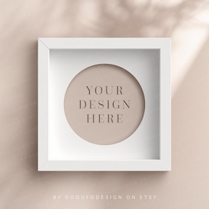 May include: White square frame with a circular cutout. The cutout has a light brown background with the text "YOUR DESIGN HERE" in a light brown font.