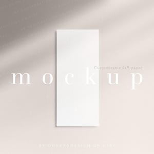 May include: A vertical rectangular white paper mockup measuring 4 by 9 inches, centered on a neutral background. The word mockup is printed in large white letters across the center, with the text Customizable 4x9 paper visible above it.