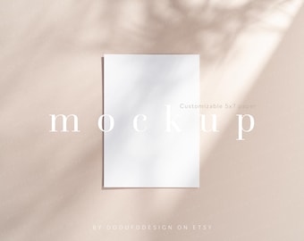 May include: A vertical rectangular white paper sheet with a 12.7x17.8 cm dimension label. The paper is centred and features soft, natural leaf-shaped shadows cast across its surface, creating a subtle contrast against the plain light beige background.