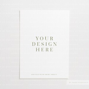 May include: A white mockup with the text "YOUR DESIGN HERE" in green text. The text "PSD FILE WITH SMART OBJECT" is also in green text at the bottom of the mockup. The text "BY DODUTODESIGN ON ETSY" is in green text at the bottom right corner of the mockup.