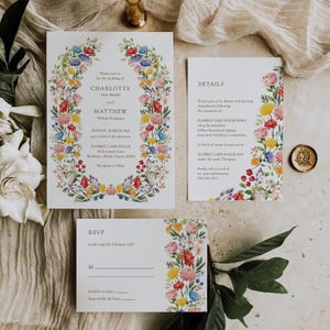 May include: A floral wedding invitation suite with a watercolor floral border. The invitation features the names Charlotte and Matthew, the date Sunday, March 28th, and the location Sunbelt Lake House. The details card includes information about the ceremony, reception, and accommodations. The RSVP card includes a space for guests to indicate their attendance.