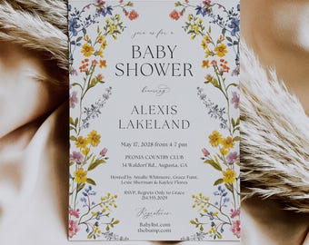 May include: A floral baby shower invitation with a white background and a border of colourful flowers. The text reads "Baby Shower honouring Alexis Lakeland" with the date, time, and location of the event. The invitation also includes the names of the hosts and RSVP information.