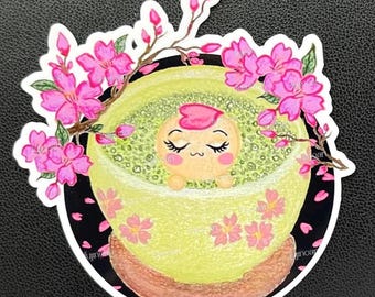 May include: A sticker featuring a cartoon character relaxing in a yellow bowl, surrounded by pink cherry blossoms. The bowl has a brown base and is decorated with more pink flowers. The background is black with pink flower petals.