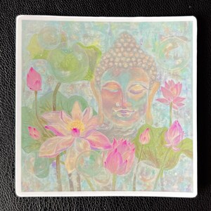 May include: A watercolor painting of a serene Buddha surrounded by pink lotus flowers. The background is a soft blue and green with a watercolor effect.