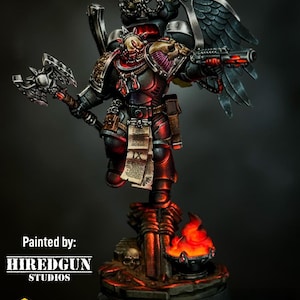 May include: A black and red space marine miniature with a skull helmet, holding a weapon and a power axe. The miniature is wearing black armour with red accents and has a pair of black wings. The miniature is standing on a base with a skull and a burning brazier. The miniature is painted to a high standard of detail.  Painted by: HIREDGUN STUDIOS. Greytide Studio. Bits only. Models not included.