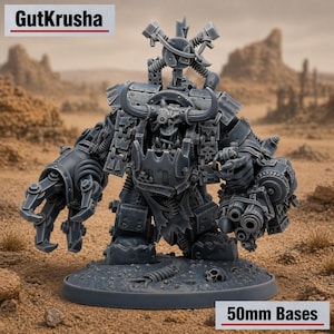 Puede incluir: Figura en miniatura gris de una máquina de guerra con brazos mecánicos y una cara con forma de calavera con cuernos. La figura tiene múltiples tubos y engranajes, y está sobre una base de 50 mm. El texto "GutKrusha" está en la parte superior.