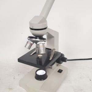 Microscopio monocular Carlsan antiguo con 3 objetivos.