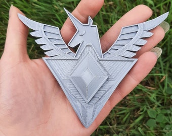 May include: A gray 3D printed pendant featuring a stylized unicorn with wings and a diamond shape in the center.