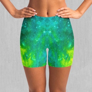 May include: A pair of athletic shorts with a galaxy print in shades of green and yellow. The shorts are made of a stretchy, comfortable fabric and are perfect for working out or running errands.