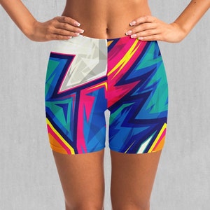 May include: A pair of athletic shorts with a colourful abstract design featuring blue, yellow, pink, and green. The shorts are made of a stretchy, comfortable fabric.